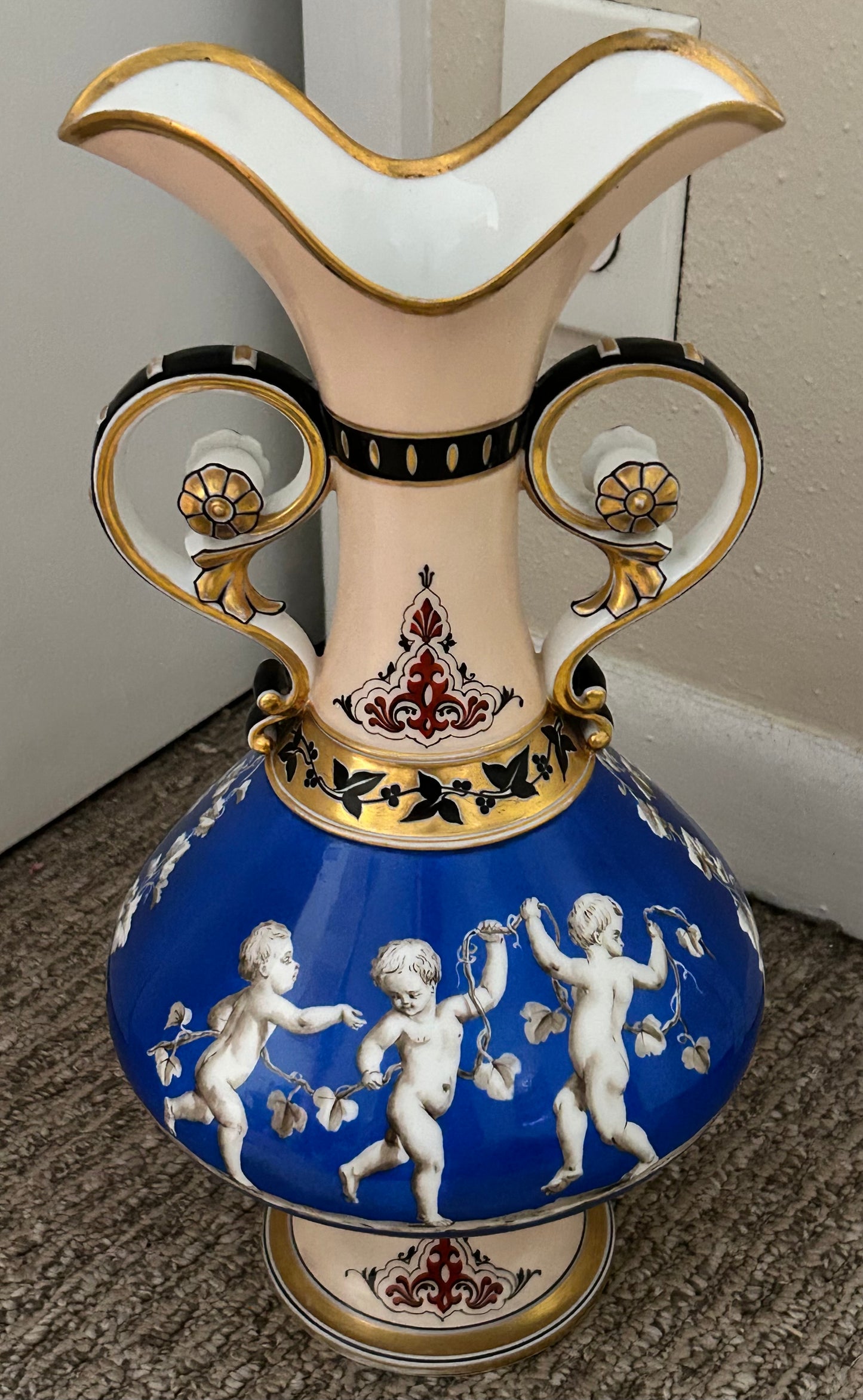 Mid 19th Century French Rococo Revival Porcelain Hand-Painted Gilded Bacchanal Putti Holding Vine Motif Double-Handled Footed Baluster Vase